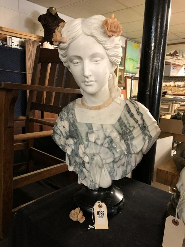 BEAUTIFULLY CARVED MARBLE BUST OF WOMAN W/FLOWERS IN: BEAUTIFULLY CARVED MARBLE BUST OF WOMAN W/FLOWERS IN HER HAIR ON BLACK MARBLE BASE, UNSIGNED, 20TH CENTURY, 1 ROSETTE IS OFF HER HAIR, BUT WE HAVE IT AS PICTURED, FROM ESTATE OF LOCAL GENTLEMAN, MEASU