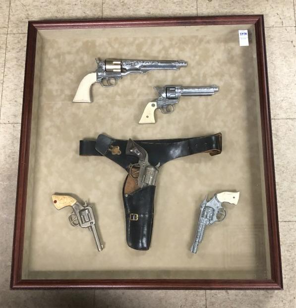 LARGE SHADOWBOX FRAME WITH (5) TOY OLDER CAP PISTOLS,: LARGE SHADOWBOX FRAME WITH (5) TOY OLDER CAP PISTOLS, ONE IN A LEATHER HOLSTER, FROM LOCAL ESTATE. GUNS INCLUDE BUFFALO BILL, KIT CARSON, MARSHALL WILD BILL HICKCOCK, STALLION 38 & CAN'T SEE A NAME ON