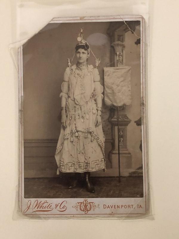 J. WHITE & CO. DAVENPORT, IOWA CABINET CARD OF BANNER: J. WHITE & CO. DAVENPORT, IOWA CABINET CARD OF BANNER GIRL POSSIBLY ADVERTISING, WITH SPOONS AROUND HER WAIST, BELLS HANGING LOWER DOWN, SMALL URNS ON HER SHOULDERS, A PEDESTAL WITH STATUE AND CLOCK O