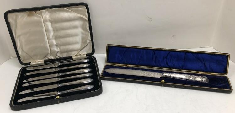 (2) ESTATE BOXED KNIVES & SERVING KNIFE, ALL HANDLES: (2) ESTATE BOXED KNIVES & SERVING KNIFE, ALL HANDLES ARE SILVER, BLADES ARE NOT. THE LARGE SERVING KNIFE HAS A BEND WHERE BLADE MEETS HANDLE. FROM LOCAL ESTATE.