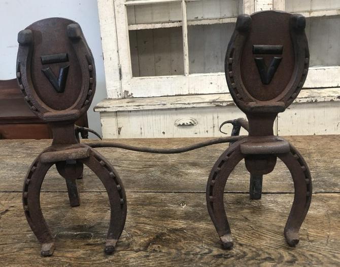 FOLK ART BAR V ANDIRONS MADE OF HORSESHOES, WITH BAR V: FOLK ART BAR V ANDIRONS MADE OF HORSESHOES, WITH BAR V LOGO, PROBABLY MADE BY JEAN VANDERLYN'S DAD, WHO OWNED THE RANCH. LIGHT SURFACE RUST, PULLED OUT OF THE ATTIC, MEASURES 18" ACROSS BY 15" HIGH. T