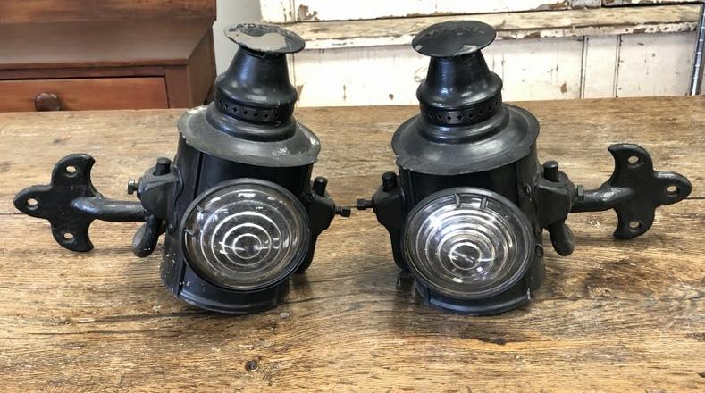 PR. ADLAKE HANGING LANTERNS WITH IRON WALL BRACKETS: PR. ADLAKE HANGING LANTERNS WITH IRON WALL BRACKETS INTACT, POSSIBLY AN OLDER BLACK PAINT STARTING TO FLAKE, BOTH GLASS LENSES ARE IN NICE CONDITION, THE LANTERNS MEASURE 10" HIGH AND APPROX. 5.5" ACR
