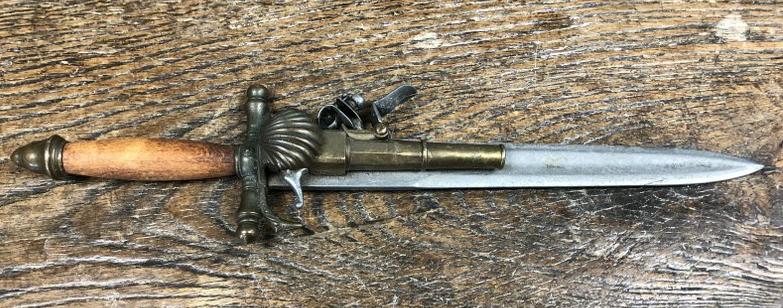 DAGGER WITH FLINT LOCK PISTOL ATTACHED TO BLADE, LOOKS: DAGGER WITH FLINT LOCK PISTOL ATTACHED TO BLADE, LOOKS LIKE IT HAS SOME AGE, I AM NOT SURE, FROM LOCAL ESTATE. NO MARKINGS, WOOD HANDLE. MEASURES 15" LONG. PROBABLY A CONVERSATION PIECEâ€¦.