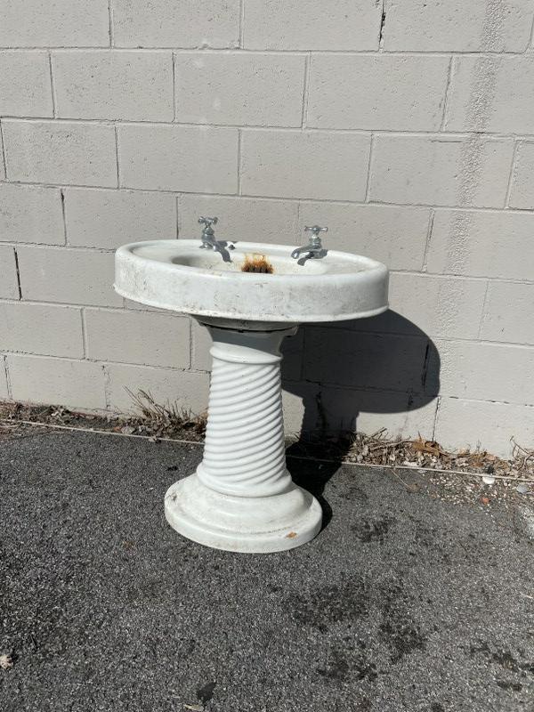 Oval porcelain sink and pedestal. Rusty spot on: Oval porcelain sink and pedestal. Rusty spot on emergency drain as pictured. 27" wide, 19" deep, 31" high.