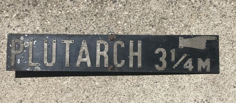 Old PLUTARCH metal street sign with hand pinting in the direction. Origin unknown, measures 4.25" x: Old PLUTARCH metal street sign with hand pinting in the direction. Origin unknown, measures 4.25" x 23" long. From Hudson, N.Y. estate of noted Art Collector Albert Burnette Roberts (1932-2021). His 4