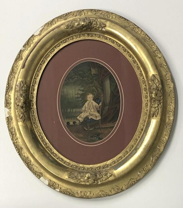 Hand Painted photograph of young child seated on chair, toy cannon on floor, forest scene behind, in (1 of 2)