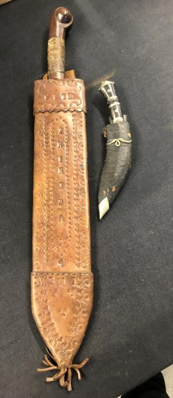 Older foreign large machete like knife and smaller knife with curved blade, with (2) small: Older foreign large machete like knife and smaller knife with curved blade, with (2) small knivesâ€¦..On the leather sheath of larger one it says TRINIDAD. Thid measures 24.5" long with nice ball