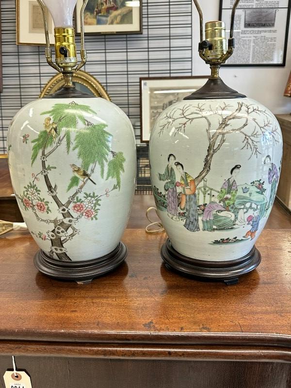 Pair older decorative Asian porcelain lamps, possibly made from ginger jars, both same size, with: Pair older decorative Asian porcelain lamps, possibly made from ginger jars, both same size, with different scenes. On wood bases, they measure approx. 13" high to top of jars, no shades, harps intact