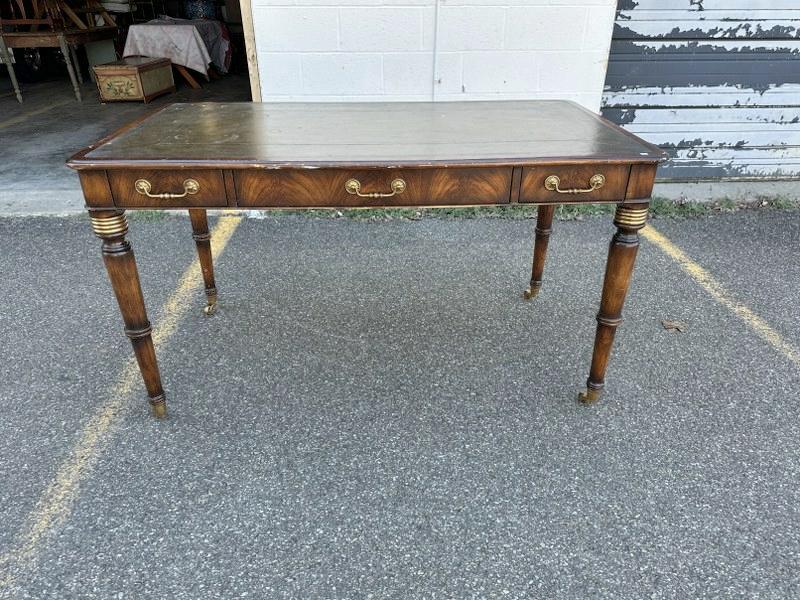 Quality leather top (3) drawer writing table or desk, has faux drawers on other side, some scuffs to: Quality leather top (3) drawer writing table or desk, has faux drawers on other side, some scuffs to the leather top, nice brass detail on legs. Measures 53.5" x 30" x 31" high. Has brass castors, nic