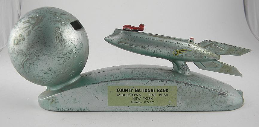 Strato Mechanical Rocket Ship Bank County Nat'l Ba: Nice working die cast STRATO mechanical rocket ship & globe bank. Advertising for COUNTY NATIONAL BANK, MIDDLETOWN, PINE BUSH AND NEW YORK. Measures 8" long.