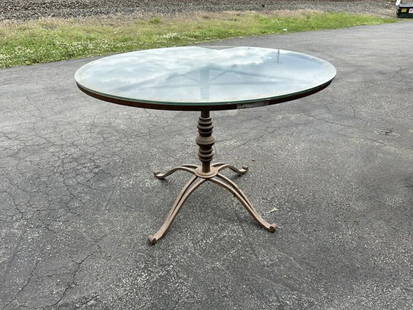 Decorative round glass table with iron base, nice form, nice estate condition. Top measures 42": Decorative round glass table with iron base, nice form, nice estate condition. Top measures 42" across x 29" high.