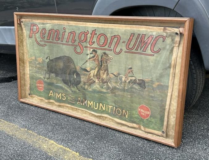 REMINGTON UMC original polychromed cloth advertising banner, hanging in oak shadowbox frame, was in: REMINGTON UMC original polychromed cloth advertising banner, hanging in oak shadowbox frame, was in corporate offices of ANDE ROONEY, depicting mounted Indian warriors hunting buffalo from horseback. 
