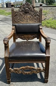 Circa 1910 carved oak armchair, with cherub head and carvings on top, with lion heads on the arms,