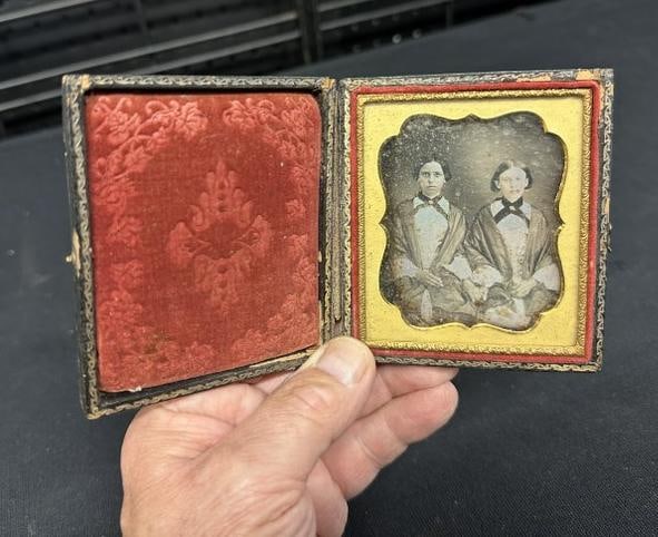 Daguerreotype of (2) younger women, one looks to be of Indian or related descent, both wearing: Daguerreotype of (2) younger women, one looks to be of Indian or related descent, both wearing similar robes with same cloth around their necks, with gold brooches or pins….Case is separated at spin