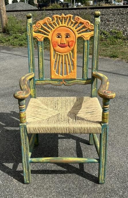 Folky painted armchair with rush seat, with sunburst on back, purchased when they lived in Santa: Folky painted armchair with rush seat, with sunburst on back, purchased when they lived in Santa Fe….structurally sound, measures 23" wide x 18" deep x 43" high.