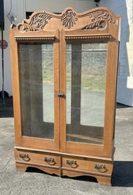 Circa 1910 carved oak 2 door china closet with 2 drawers on base, has adjustable shelves, original