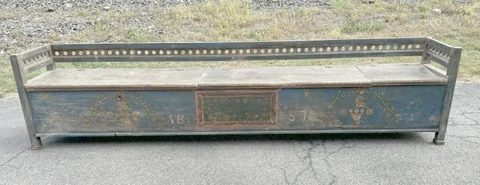 Early long lift top bench in old blue paint and decorated front, dated on front 1857. Has 3