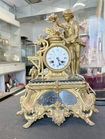 Victorian gilt white metal figural mantel clock with man watering flowers