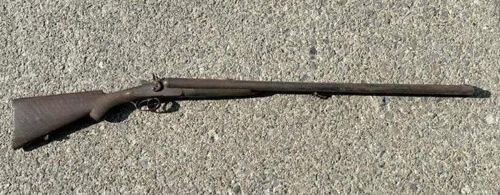 Old double barrel shotgun, rusted all over, can't see the name, was on display hanging on local