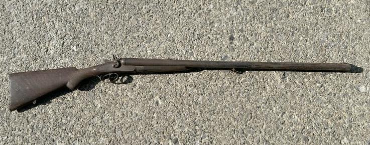 Old double barrel shotgun, rusted all over, can't see the name, was on display hanging on local: Old double barrel shotgun, rusted all over, can't see the name, was on display hanging on local estate's wall.