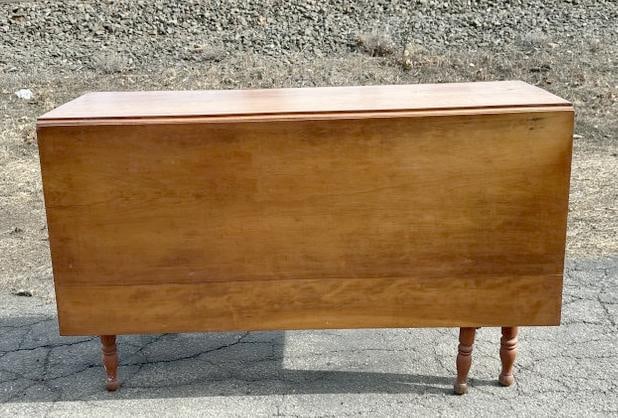 19th c cherry long leaf dropleaf table, in old finish. Closed it measures 48" wide x 18" deep x 29": 19th c cherry long leaf dropleaf table, in old finish. Closed it measures 48" wide x 18" deep x 29" high, the (2) drop leaves measure 21" wide each…..