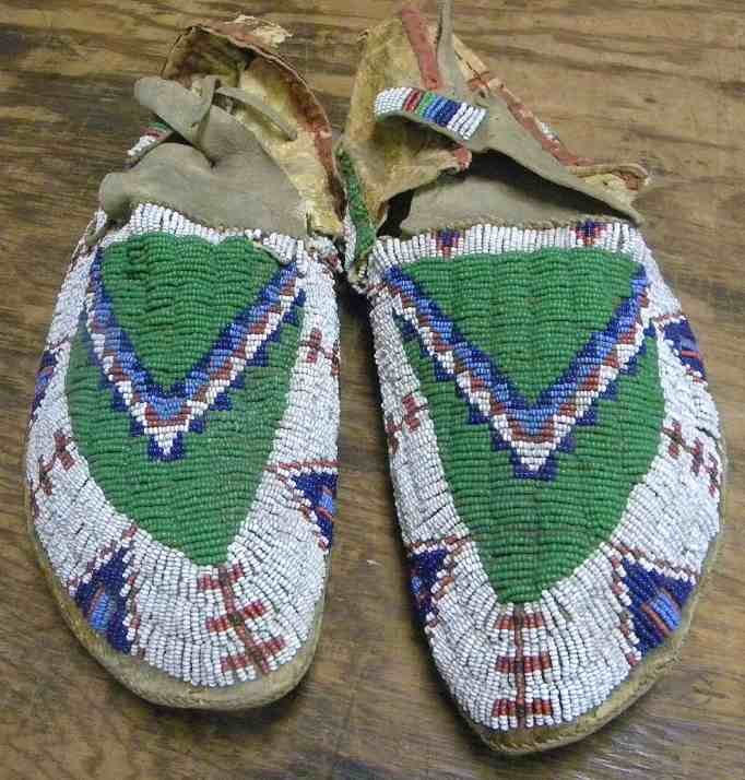 Pair 19th C PLAINS INDIAN BEADED MOCCASINS Sinew: Pair 19th C PLAINS INDIAN BEADED MOCCASINS , Sinew, raw hide, green, red, white, blue trade beads, trade cloth, good condition, small holes in back, as pictured. Measure 10 1/2" front to back.