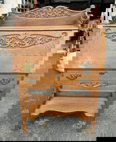 Circa 1910 oak carved dropfront desk with cubby holes inside, nice fancy original brass hardware.