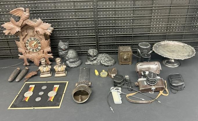 Misc. estate lot to include cuckoo clock, (2) iron cat doorstops (not old ), silverplate cake stand,: Misc. estate lot to include cuckoo clock, (2) iron cat doorstops (not old ), silverplate cake stand, cast iron old safe bank, reissued Olympic Medals, WWI era compass in case, MINOLTA older 35 mm came