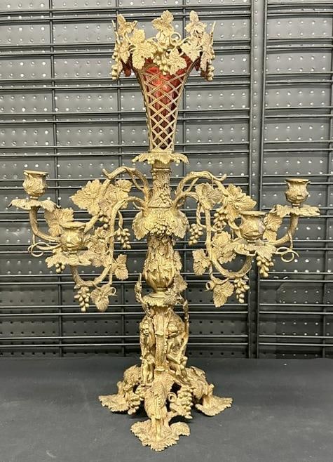 Fancy gilt bronze (4) arm candelabra with (3) figures on base, and cranberry glass insert on top,: Fancy gilt bronze (4) arm candelabra with (3) figures on base, and cranberry glass insert on top, nice estate condition, measures 26" high x 19.5" across the arms. From fine estate in Scarsdale, N.Y.