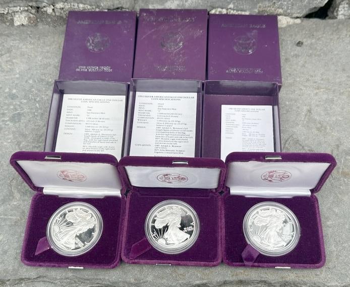 (3) fine silver AMERICAN EAGLE One Dollar Coins in cases and boxes, from local estate we are (1 of 1)