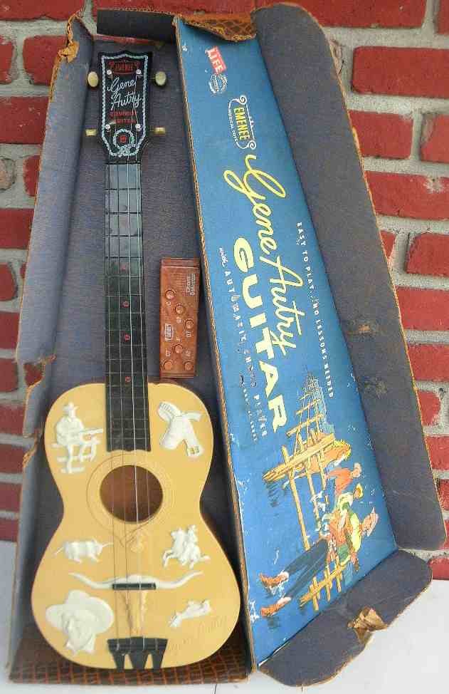 Vintage Gene Autry Guitar in Original Case: Gene Autry guitar in box with automatic chord player, made by Emenee musical toys, no 601, guitar in good condition, box is torn and handle taped, as pictured
