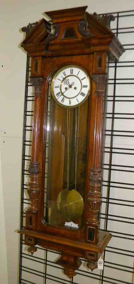 ROSEWOOD VICTORIAN INLAID 47" HIGH WALL CLOCK, 2 BRASS : ROSEWOOD VICTORIAN INLAID 47" HIGH WALL CLOCK, 2 BRASS WEIGHTS, LARGE PENDULUM, PORCELAIN DIAL WITH HAIRLINE CRACKS, SMALL PEICE OF MOLDING TRIM MISSING OFF THE FRONT, UNSURE OF MAKER, WAS RUNNING IN