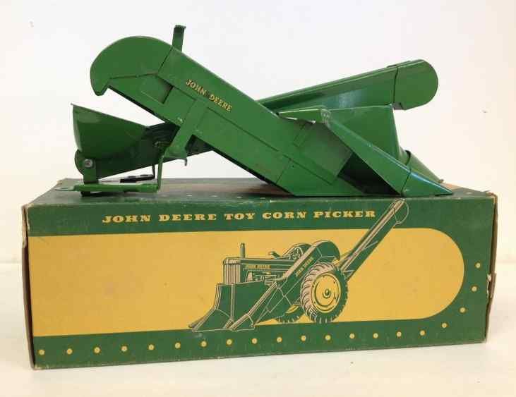 JOHN DEERE EARLY 1950'S TOY CORN PICKER WITH ORIGINAL: JOHN DEERE EARLY 1950'S TOY CORN PICKER WITH ORIGINAL BOX, MEASURES 11" FRONT TO BACK, HAS SOME RUST UNDERNEATH AND SOME PAINT WEAR, FROM OLD FAMILY ESTATE IN COLORADO, AS PICTURED