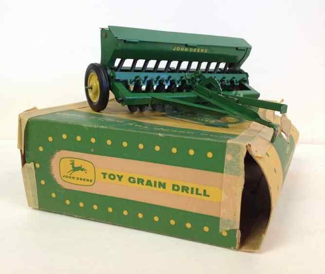 JOHN DEERE EARLY 1950'S TOY GRAIN DRILL WITH ORIGINAL: JOHN DEERE EARLY 1950'S TOY GRAIN DRILL WITH ORIGINAL BOX(TAPED), MEASURES 7" FRONT TO BACK, HAS SOME SCRATCHES, FROM OLD FAMILY ESTATE IN COLORADO, AS PICTURED