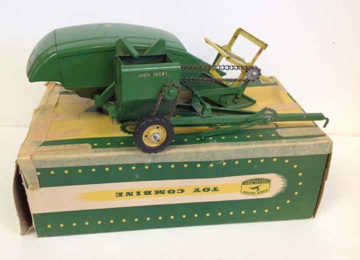 JOHN DEERE EARLY 1950'S TOY COMBINE WITH ORIGINAL: JOHN DEERE EARLY 1950'S TOY COMBINE WITH ORIGINAL BOX(TAPED), MEASURES 14" FRONT TO BACK, HAS SOME WEAR ON PAINT, SOME RUST SPOTS ON BOTTOM, FROM OLD FAMILY ESTATE IN COLORADO, AS PICTURED