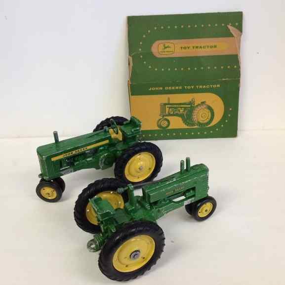 2 JOHN DEERE EARLY 1950'S DIE CAST TOY TRACTORS WITH 1: 2 JOHN DEERE EARLY 1950'S DIE CAST TOY TRACTORS WITH 1 ORIGINAL BOX MISSING FLAPS, BOTH MEASURES 8" FRONT TO BACK, BOTH HAVE PAINT LOSS, 1 MISSING STEERING WHEEL, FROM OLD FAMILY ESTATE IN COLORADO, A