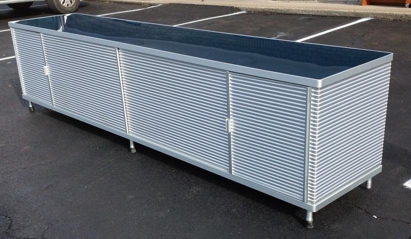 DESIGNER MODERN CORRAGATED ALUMINUM CREDENZA WITH BLUE: DESIGNER MODERN CORRAGATED ALUMINUM CREDENZA WITH BLUE GLASS TOP AND 3 GLASS SHELVES, HAS 2 DOORS ON THE END AND 2 SLIDING DOORS IN CENTER, HAS FINISHED CORRAGATED ALUMINUM BACK, MEASURES 110 1/4" LON