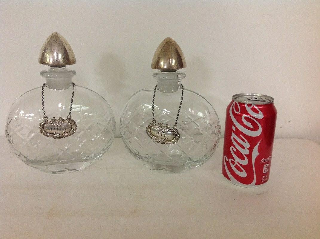 PAIR CRYSTAL & STERLING TOP AND TAGS LIQUOR DECANTERS: PAIR CRYSTAL & STERLING TOP AND TAGS LIQUOR DECANTERS FROM LOCAL ESTATE, TOPS AND TAGS MARKED STERLING. NICE OVERALL CONDITION, TAGS ARE SCOTCH AND RYE. MEASURE 8 1/4" HIGH.