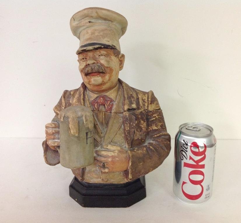 TERRA COTTA FIGURAL HUMIDOR W/MAN DRINKING A MUG OF: TERRA COTTA FIGURAL HUMIDOR W/MAN DRINKING A MUG OF BEER, MARKED ON BOTTOM J M 3, 3310, SOME CHIPS ON BRIM OF HIS CAP, SURFACE WEAR TO PAINT THROUGHOUT, MEASURES 12" HIGH, AS PICTURED