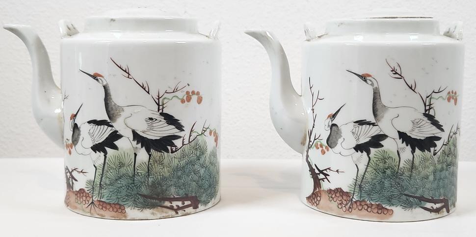 Two Chinese Jingdezhen Porcelain Crane Tea Pots: A pair of Chinese Porcelain tea pots, each featuring cranes on the front panel and a message on the back. Each pot has a Jingdezhen factory mark on the bottom, indicating the pieces are likely from th