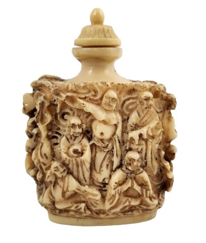 Asian Antique Bone Snuff Bottle: Snuff bottle, seems to be carved out of bone, featuring raised imagery of several individuals. The bottle is 3" tall and 2 1/4" wide.