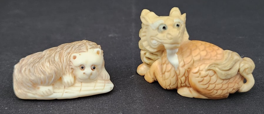Hand Carved Japanese Dragon & Lion Figurines: 2 hand carved Japanese figurines, possibly Netsuke, carved from bone and boxwood. The lot includes a Dragon and what looks to be a Lion. Please see the photos provided for size and make details.