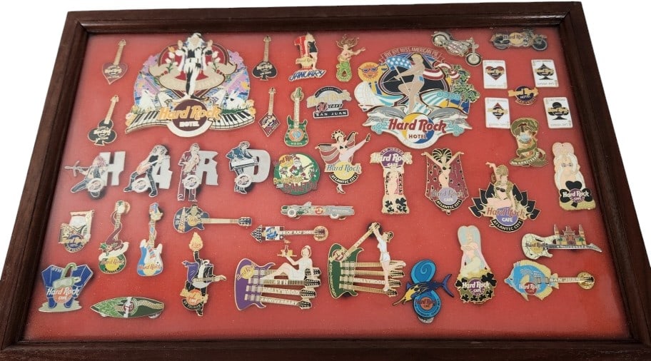 Hard Rock Hotel Casino Las Vegas Pins: 43 enamel trading pins from the Hard Rock family of Casinos, Hotels, and Cafes. The pins are housed in a shadowbox case measuring 18" x 12" x 1 3/4". Some pins may have foam stuck to the back due to t