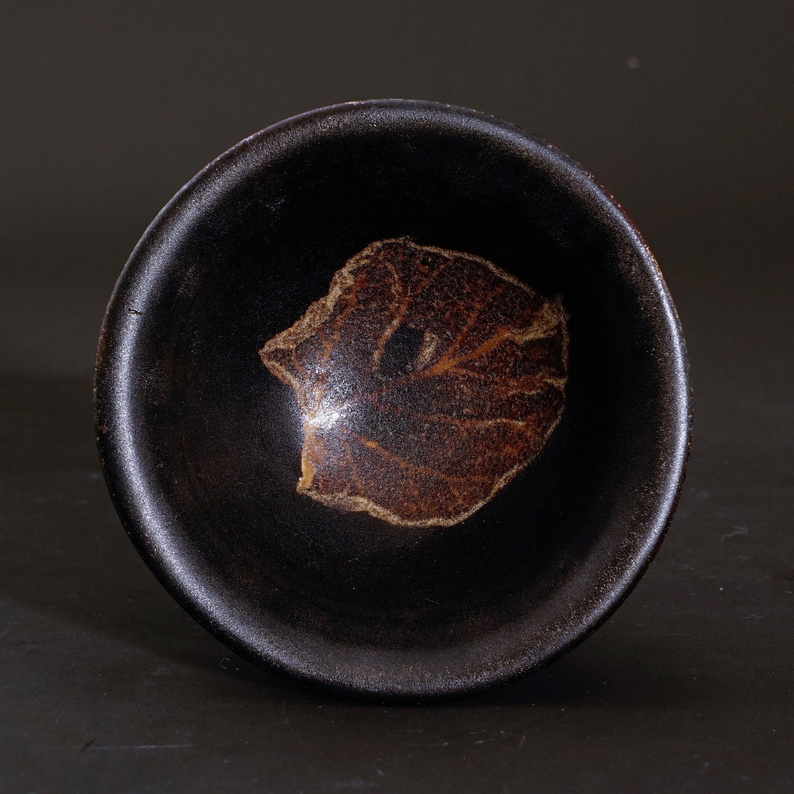 A cup from Jizhou warewith a leaf patternin Song Dynasty: A cup from Jizhou warewith a leaf patternin Song Dynasty High:5.1cm Diam:11cm