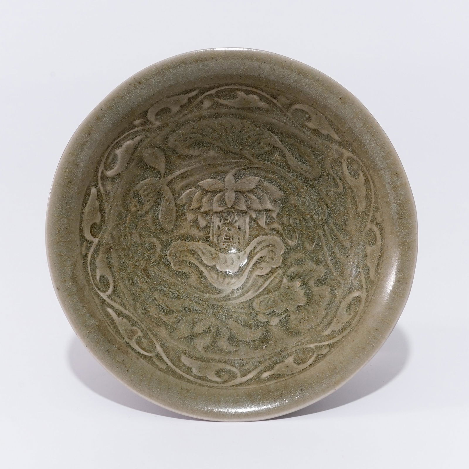 A Yaozhou ware celadon bowl with a floral pattern in the Jan Dynasty: A Yaozhou ware celadon bowl with a floral pattern in the Jan DynastyH:4.8cm Diam:11.3cm