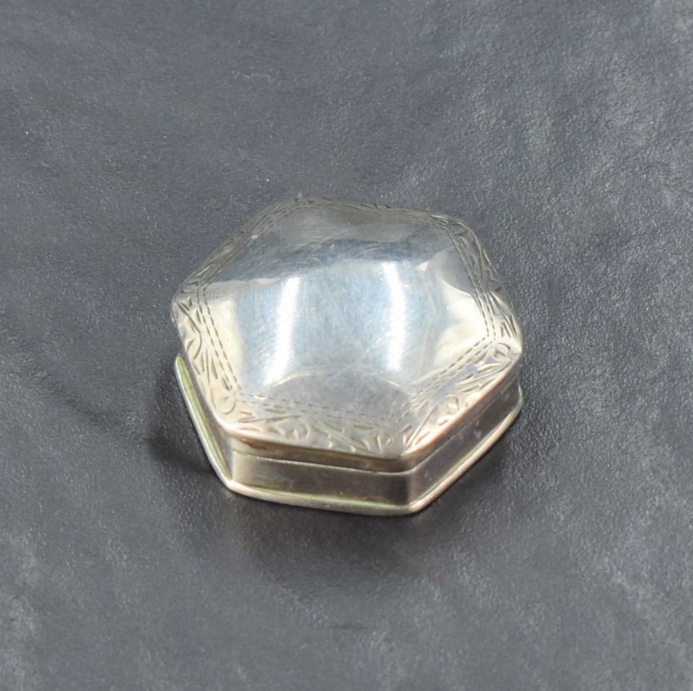An imported silver 19th century design pill box, of domed and hinged hexagonal form with engraved: An imported silver 19th century design pill box, of domed and hinged hexagonal form with engraved border, import marks for 1994, maker C M E Jewellery Ltd, 3.3cm, 11grams