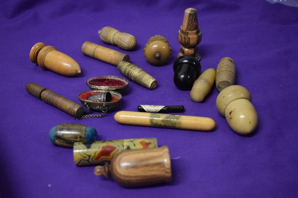 A collection of antique needle cases, thimble holders and pin cushions, including Mauchline ware and: A collection of antique needle cases, thimble holders and pin cushions, including Mauchline ware and 1907 dated turned boxwood thimble holder housing Charles Horner hallmarked silver thimble. overall