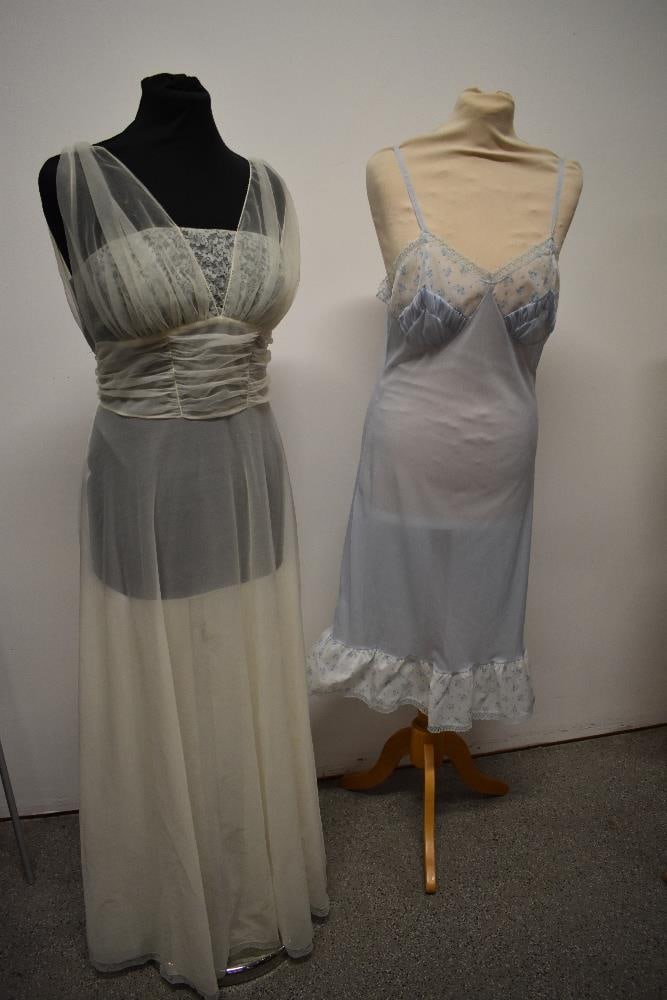 A 1950s semi sheer Kayser Bondor nylon nightdress in white with blue lace inserts to bodice, sold: A 1950s semi sheer Kayser Bondor nylon nightdress in white with blue lace inserts to bodice, sold with a 1950s blue nylon slip with floral pattern to bodice and hem.