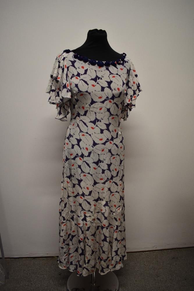 A 1930s day dress, having abstract leaf pattern, beautiful fluted sleeves and amazing panelling to: A 1930s day dress, having abstract leaf pattern, beautiful fluted sleeves and amazing panelling to bottom of skirt, side press stud fastening, smaller size. bust approx 32 inches, waist approx 27 inch