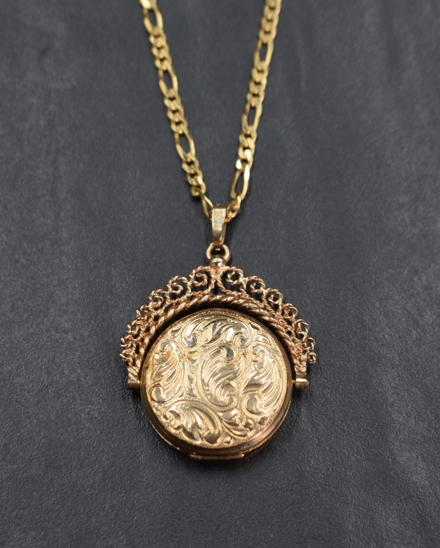 A 9ct gold spinning locket having floral motif engraving with a decorative rope-work frame, on a 9ct (1 of 2)